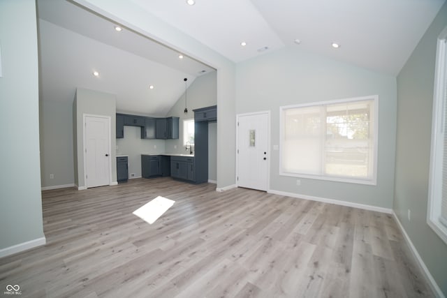 unfurnished living room featuring high vaulted ceiling and light hardwood / wood-style floors