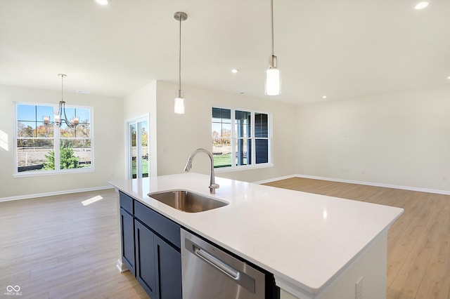 kitchen with light hardwood / wood-style flooring, sink, stainless steel dishwasher, and an island with sink