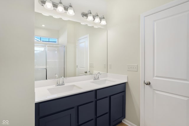 bathroom with a shower with door and vanity