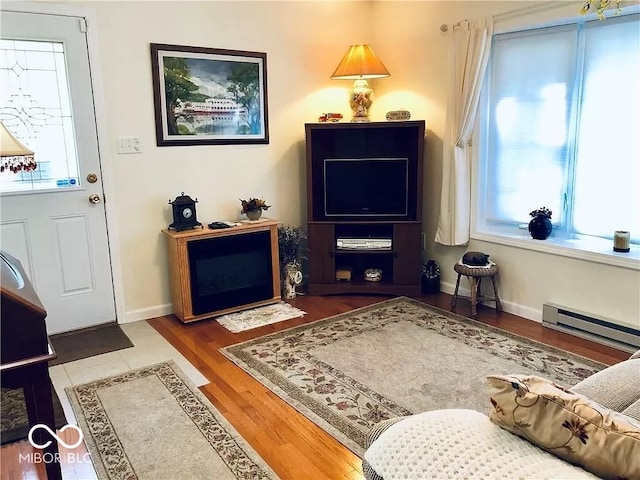 interior space with baseboard heating, hardwood / wood-style flooring, and a healthy amount of sunlight