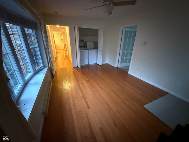 unfurnished room featuring light hardwood / wood-style floors, washer and clothes dryer, and ceiling fan