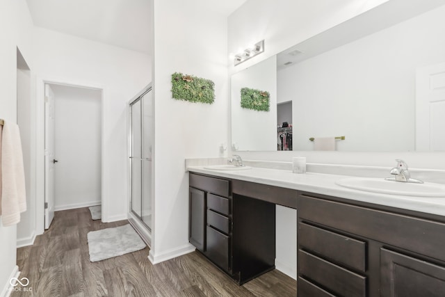 bathroom featuring a shower with door, hardwood / wood-style floors, and vanity