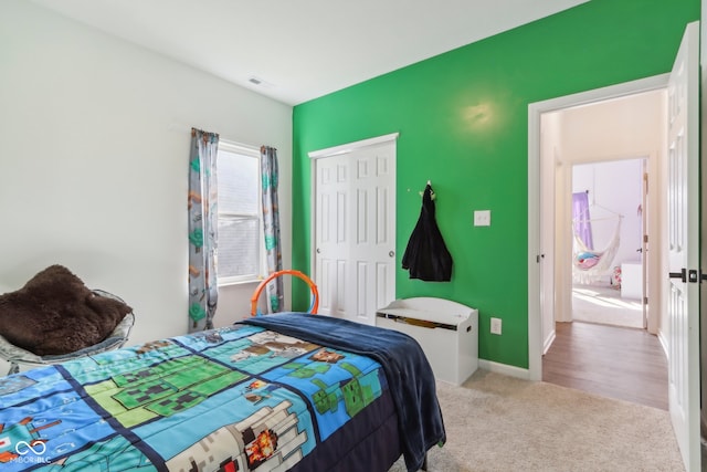 bedroom with light carpet and a closet