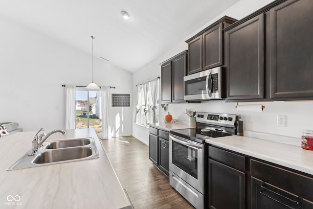 kitchen with lofted ceiling, dark wood-type flooring, sink, pendant lighting, and stainless steel appliances