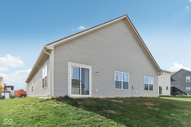 rear view of house featuring a yard