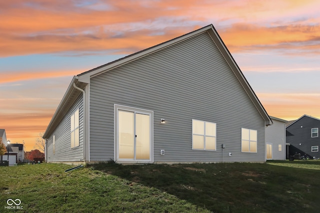 back house at dusk with a yard