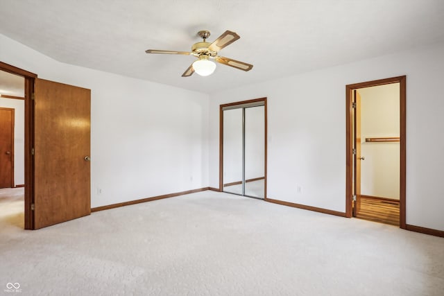 unfurnished bedroom with light carpet, baseboards, and a ceiling fan