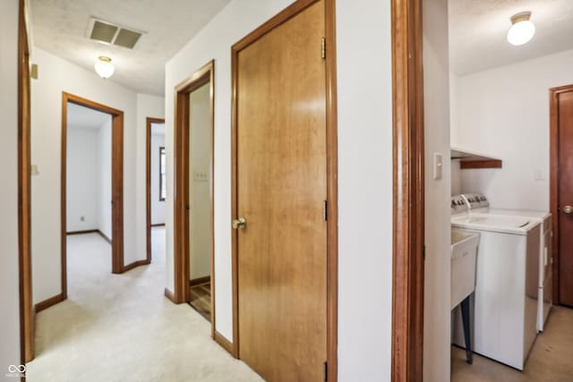 corridor featuring separate washer and dryer and baseboards