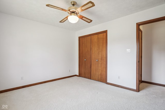 unfurnished bedroom with light carpet, a textured ceiling, a closet, and ceiling fan