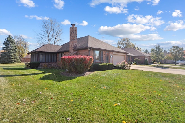 view of side of home with a garage, concrete driveway, a yard, and a chimney