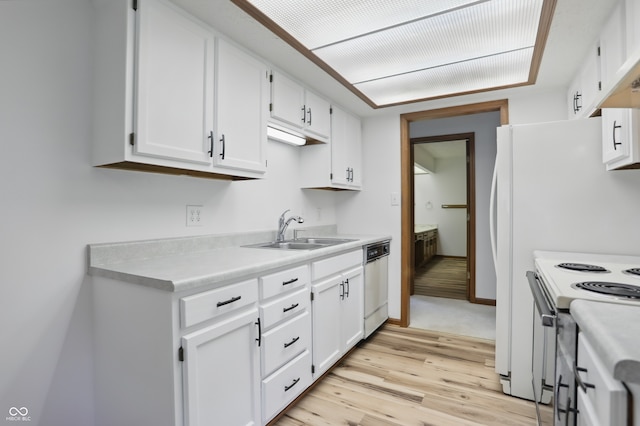 kitchen featuring white appliances, a sink, white cabinets, light countertops, and light wood-type flooring