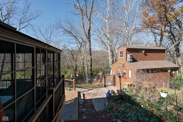 view of yard with a sunroom, an outdoor structure, and a wooden deck