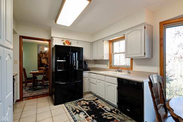 kitchen with black appliances, sink, light tile patterned flooring, and white cabinets