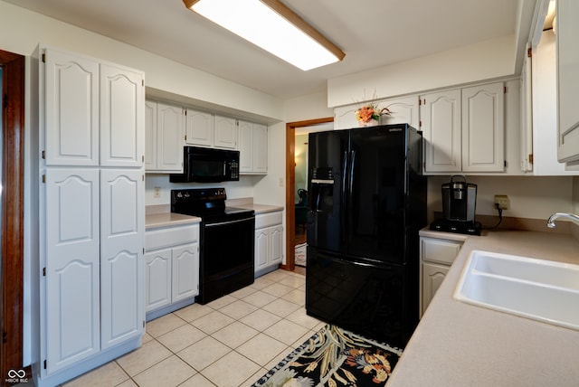 kitchen featuring black appliances, white cabinetry, sink, and light tile patterned flooring