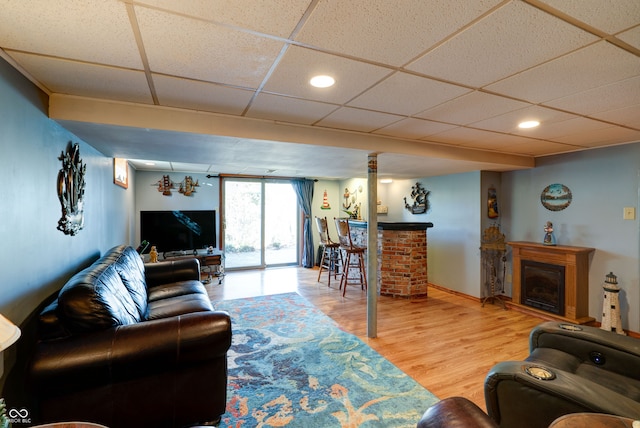 living room with hardwood / wood-style floors and a drop ceiling