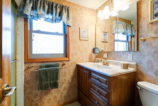 bathroom featuring toilet, vanity, and a wealth of natural light