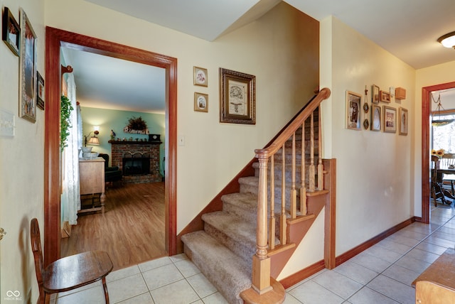 staircase featuring a fireplace and tile patterned floors