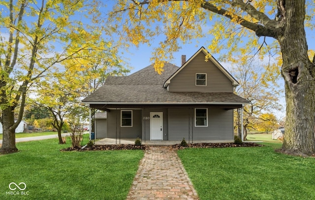 view of front of property featuring covered porch and a front lawn