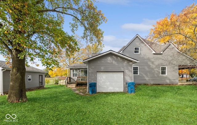 rear view of house featuring a deck, a garage, and a lawn