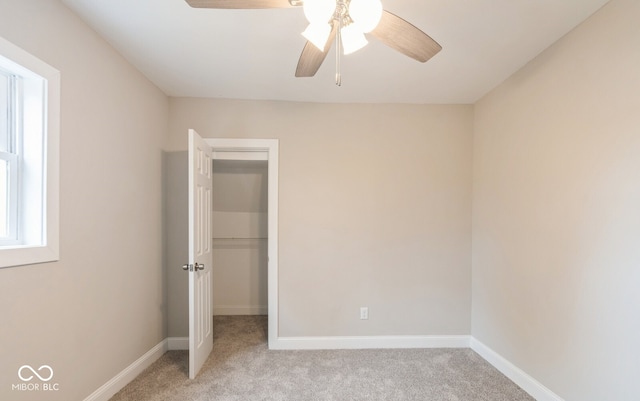 unfurnished bedroom featuring light carpet, a closet, and ceiling fan