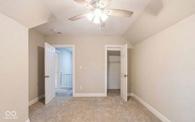 unfurnished bedroom featuring a closet, ceiling fan, lofted ceiling, and light colored carpet