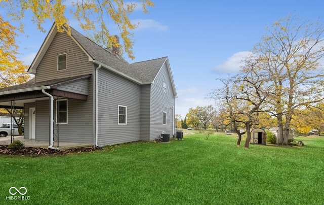 view of side of property with a yard and cooling unit