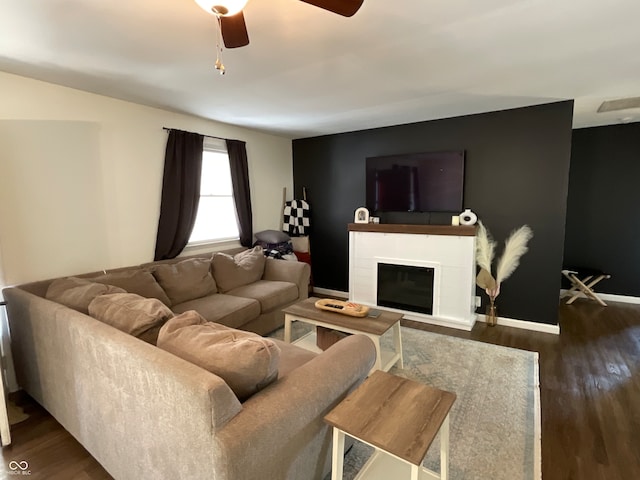 living room featuring dark wood-type flooring and ceiling fan