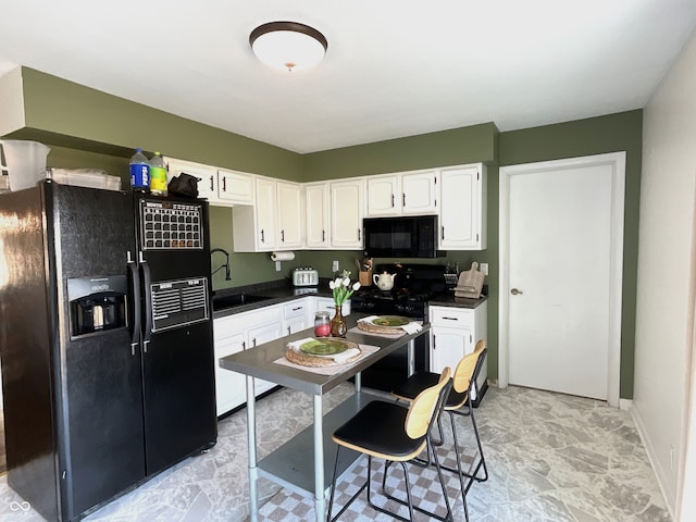 kitchen featuring sink, black appliances, and white cabinets