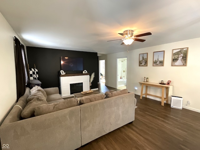 living room featuring ceiling fan and dark hardwood / wood-style flooring