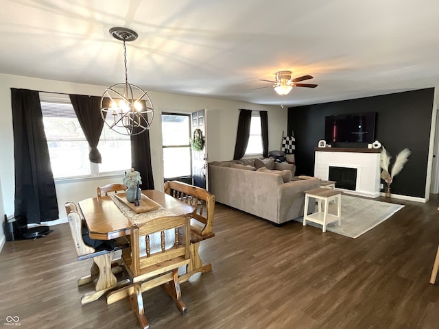 dining area featuring ceiling fan with notable chandelier, plenty of natural light, and dark hardwood / wood-style floors