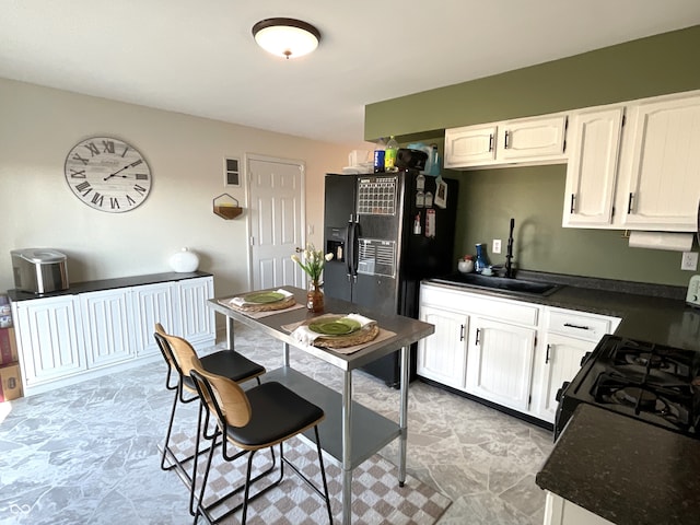 kitchen with white cabinetry, black appliances, and sink