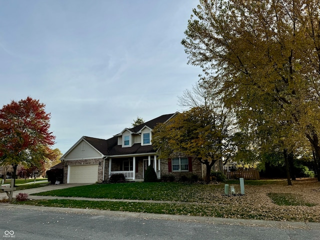 view of front of home featuring a garage, covered porch, and a front lawn