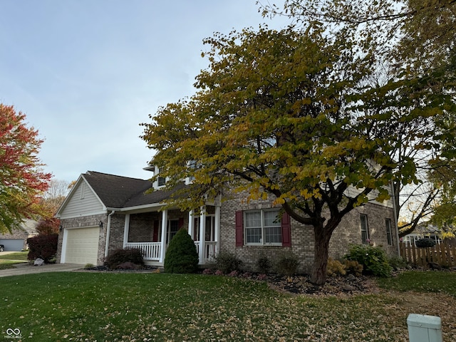 view of front of property with a porch, a garage, and a front lawn