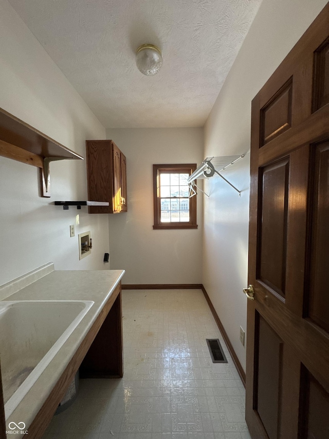 clothes washing area featuring sink, cabinets, hookup for a washing machine, electric dryer hookup, and a textured ceiling