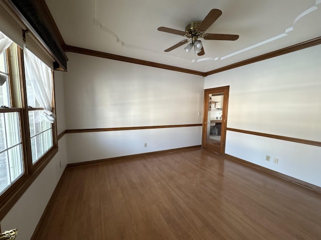 empty room featuring hardwood / wood-style flooring, ornamental molding, and ceiling fan