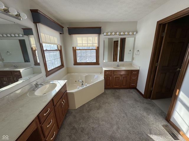 bathroom featuring vanity, a textured ceiling, and a bathing tub