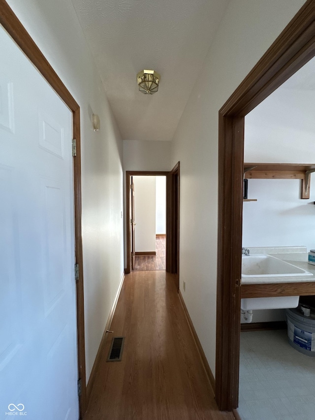 hall featuring sink and dark hardwood / wood-style floors