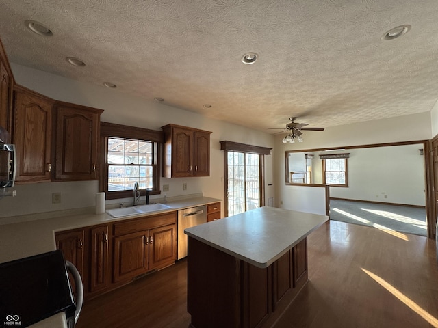 kitchen with dark wood-type flooring, sink, range, a center island, and stainless steel dishwasher