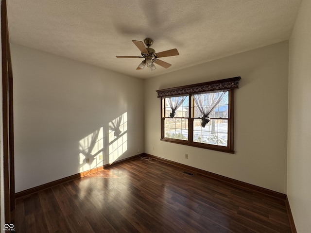 unfurnished room featuring ceiling fan, dark wood-type flooring, and a textured ceiling