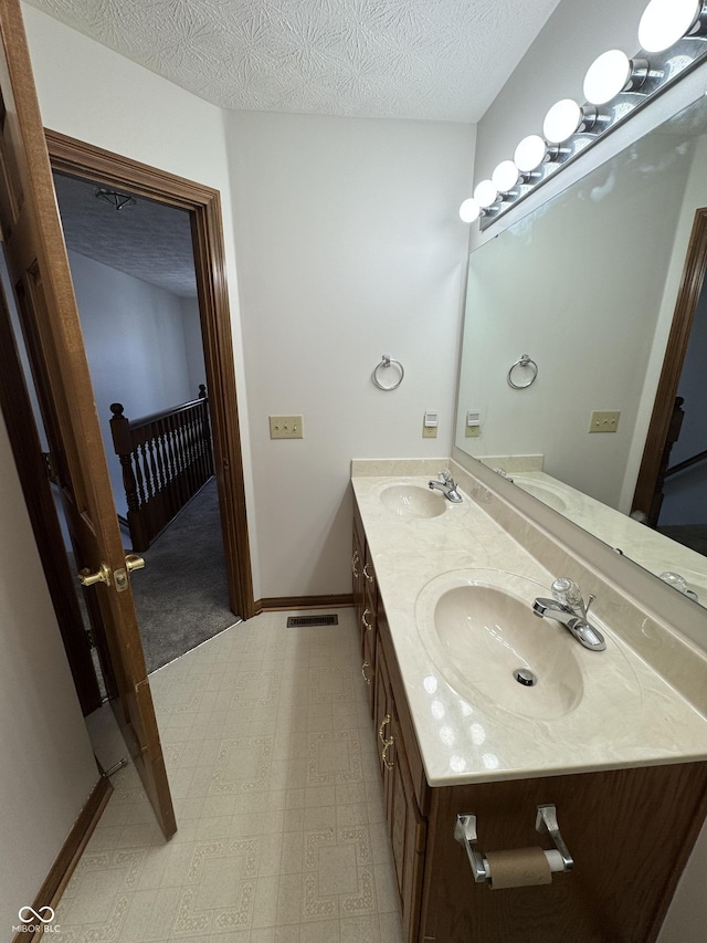 bathroom with vanity and a textured ceiling