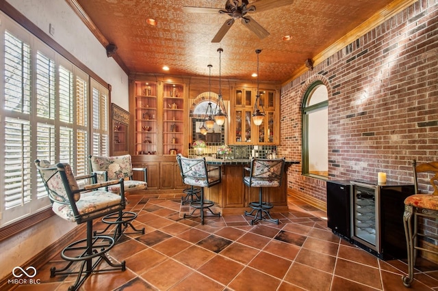 bar featuring decorative light fixtures, brick wall, ornamental molding, and a wealth of natural light