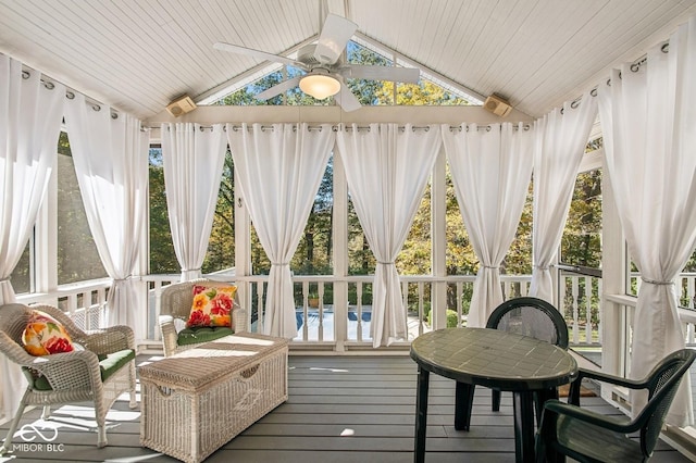 sunroom with ceiling fan, wood ceiling, a wealth of natural light, and vaulted ceiling