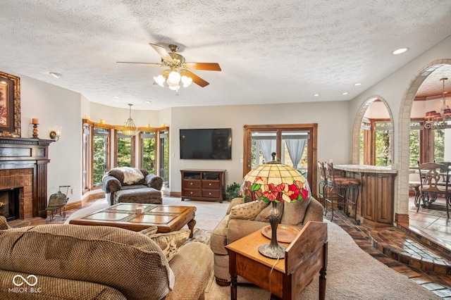 tiled living room featuring ceiling fan and a textured ceiling