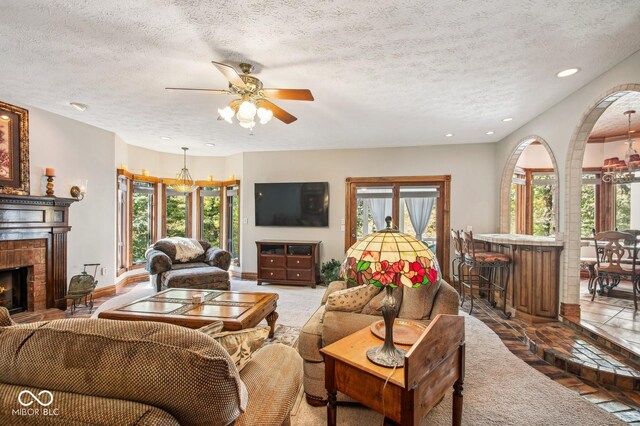 6902 Creekridge Trl, Indianapolis, IN 46256 - living room with a textured ceiling, recessed lighting, ceiling fan, a brick fireplace, and baseboards