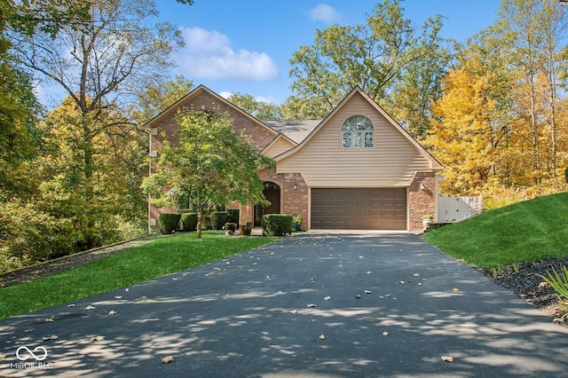 6902 Creekridge Trl, Indianapolis, IN 46256 - traditional home with brick siding, asphalt driveway, an attached garage, and a front yard