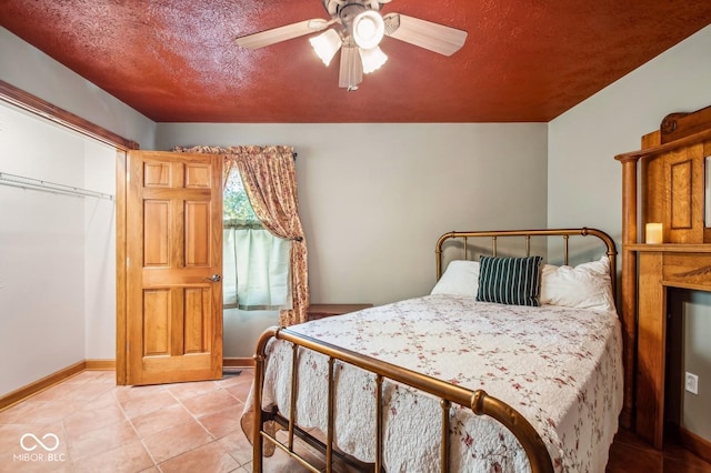 bedroom with a textured ceiling, a closet, ceiling fan, and light tile patterned flooring