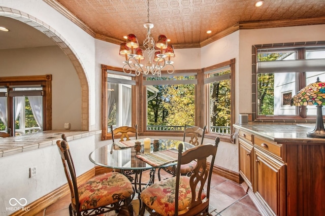 dining area featuring light tile patterned flooring, crown molding, and a chandelier