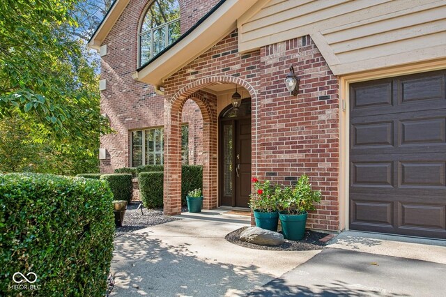 6902 Creekridge Trl, Indianapolis, IN 46256 - view of exterior entry with a balcony, brick siding, and an attached garage