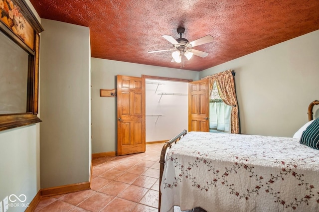 tiled bedroom with ceiling fan and a textured ceiling