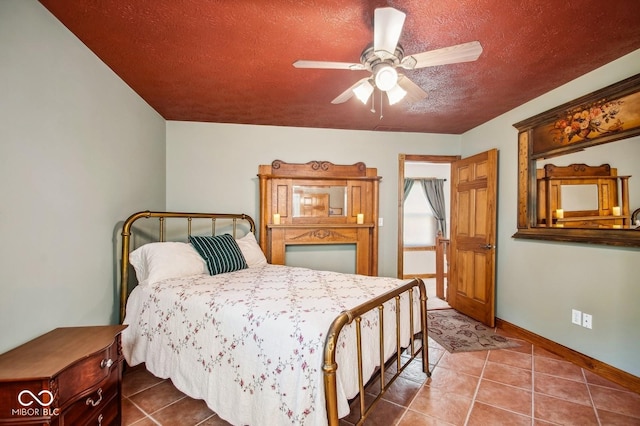 bedroom with ceiling fan, tile patterned flooring, and a textured ceiling